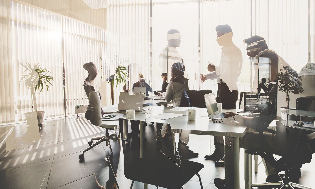 Silhouettes Of People Against The Window. A Team Of Young Businessman Working And Communicating Toge Silhouettes of people against the window. A team of young businessman working and communicating together in an office. Corporate business team and manager in a meeting.